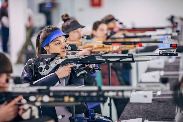 Group of women, young women on rifle shooting training indoors.